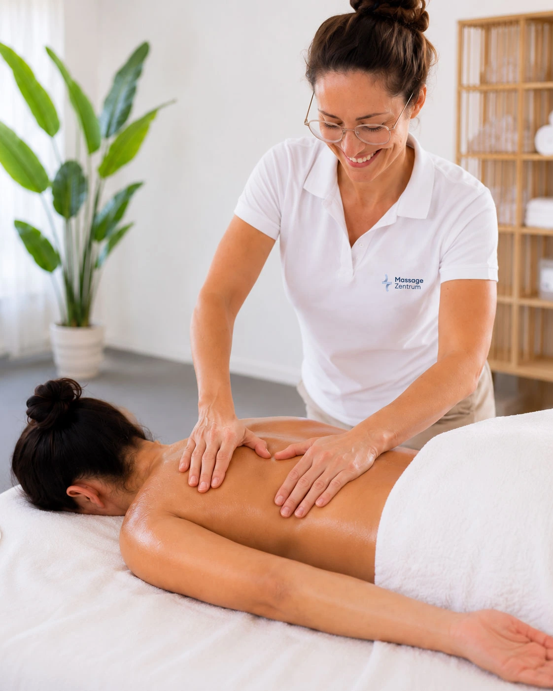 Therapeutin bearbeitet den verspannten Nacken-Schulter-Bereich bei einer therapeutischen Massage in der Praxis Eschen